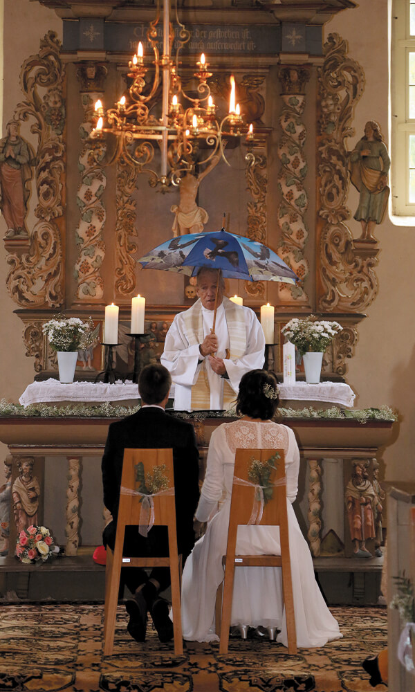 Hochzeitsbild Mann und Frau in der Kirche mit Pastor