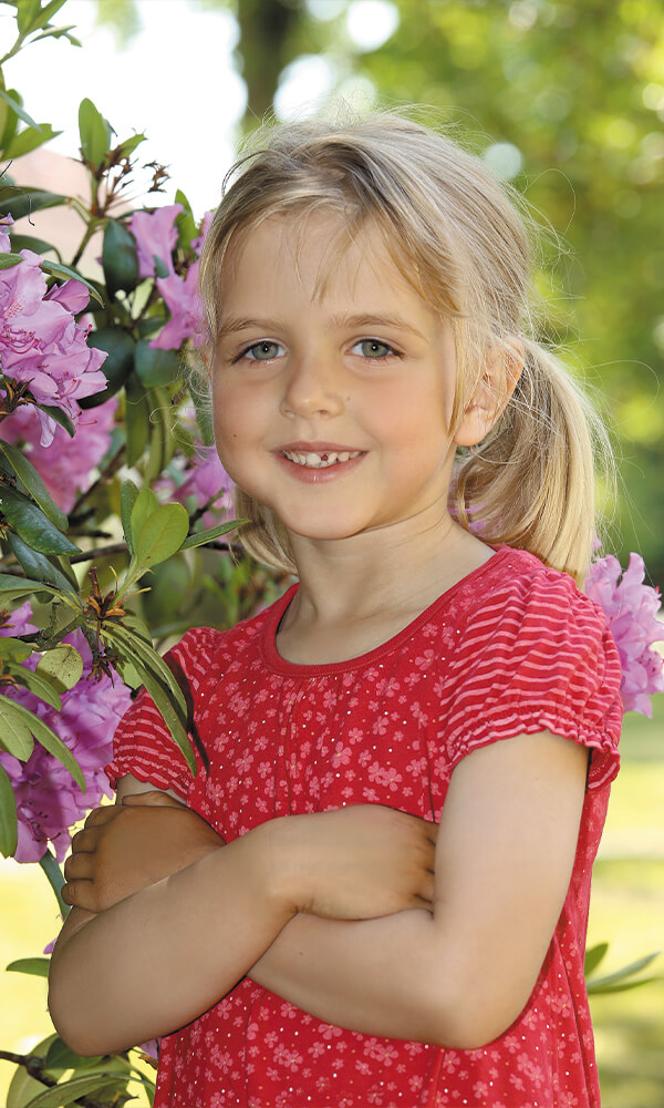 Kindergarten Bild Kind stehend draußen Blumen