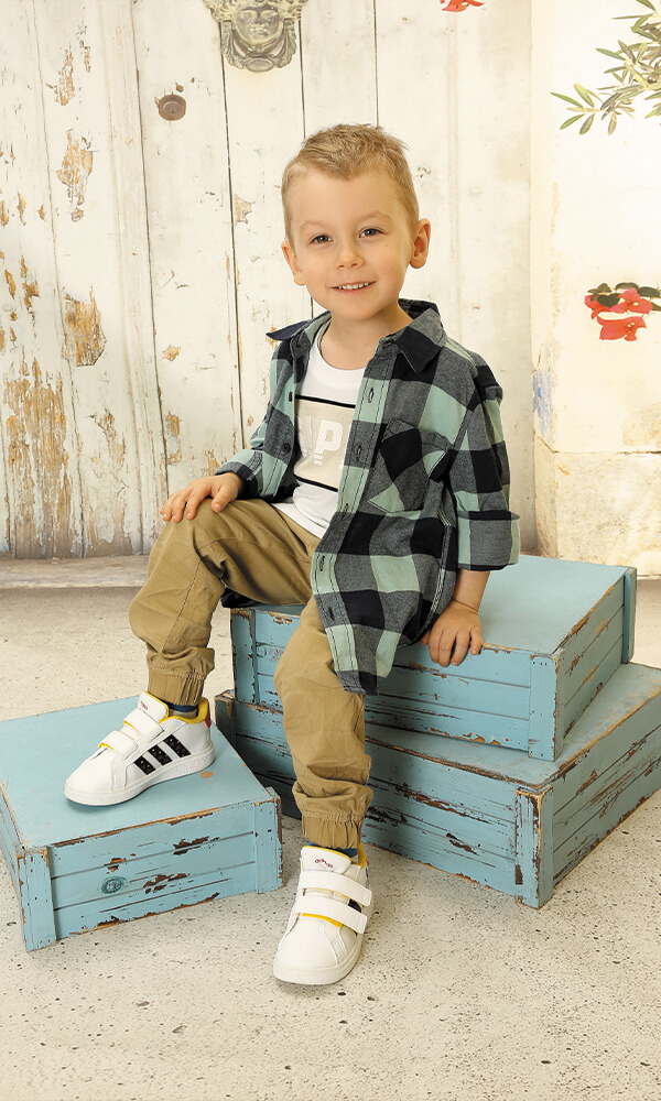 Kindergarten Bild Kind sitzend auf blauen Holzkisten