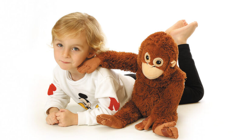 Kindergarten Bild Kind liegend weißer Hintergrund mit Kuscheltier