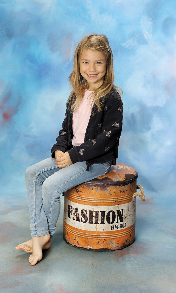 Kindergarten Bild Kind auf Fass sitzend