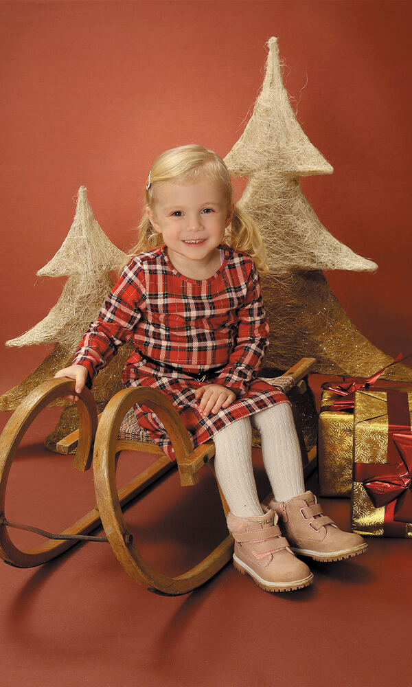 Kindergarten Bild Kind sitzend Schlitten Holz Weihnachten