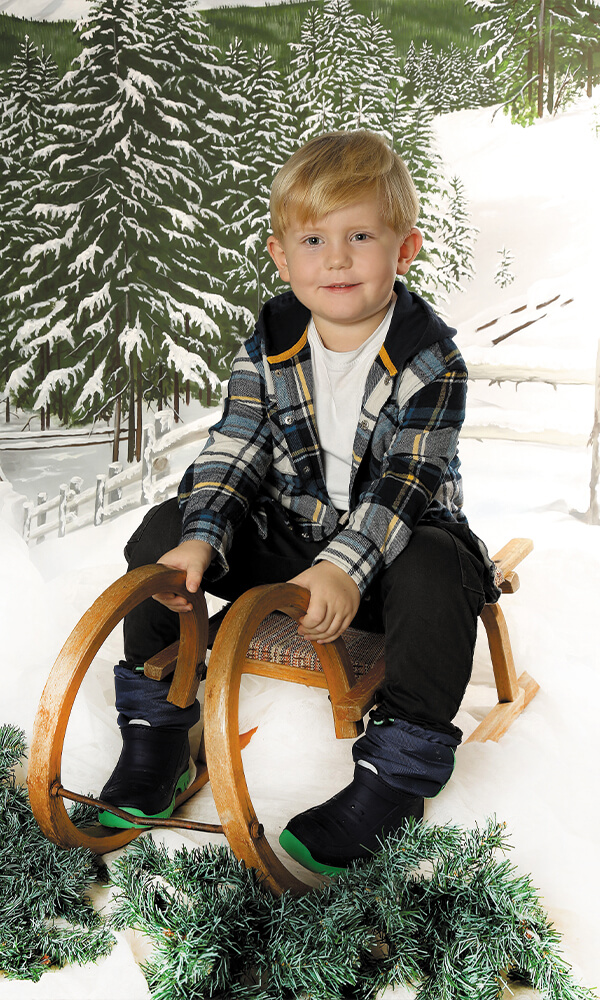 Kindergarten Bild Kind auf Schlitten